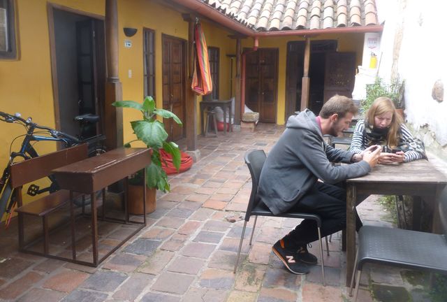 Two visitors at Alegria's Hostel enjoy some leisure time in the beautiful courtyard. 