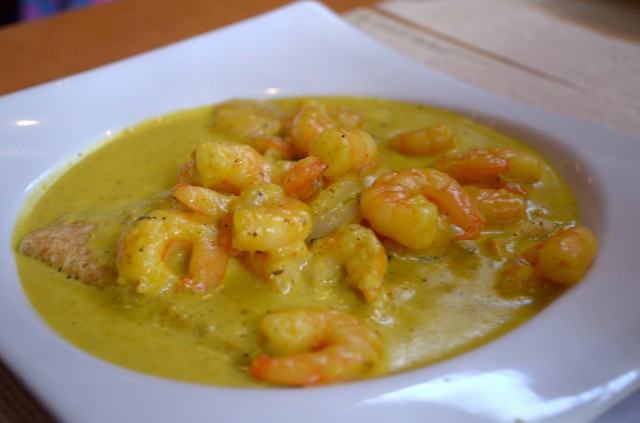 Crepe of shrimp in curry sauce, served with a basket of bread.