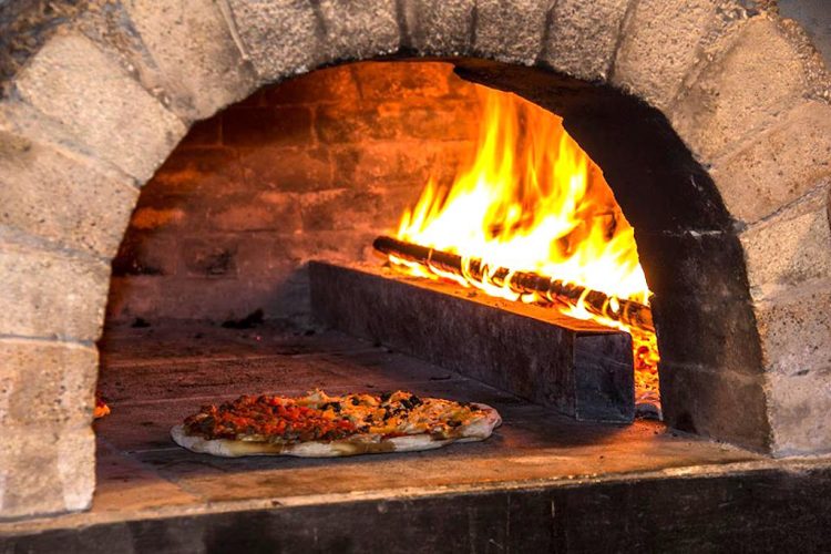 Brick-oven cooked pizza at Pizza en Leña, photo courtesy of Pizza en Leña