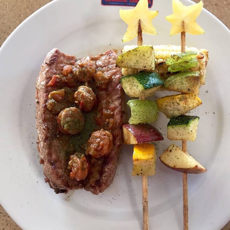 Sirloin steak and pork sausage, with roasted corn and skewers of vegetables and fruits, photo courtesy of Mama Santa