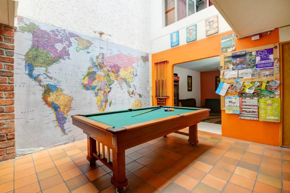 There's a pool table next to the bar. 