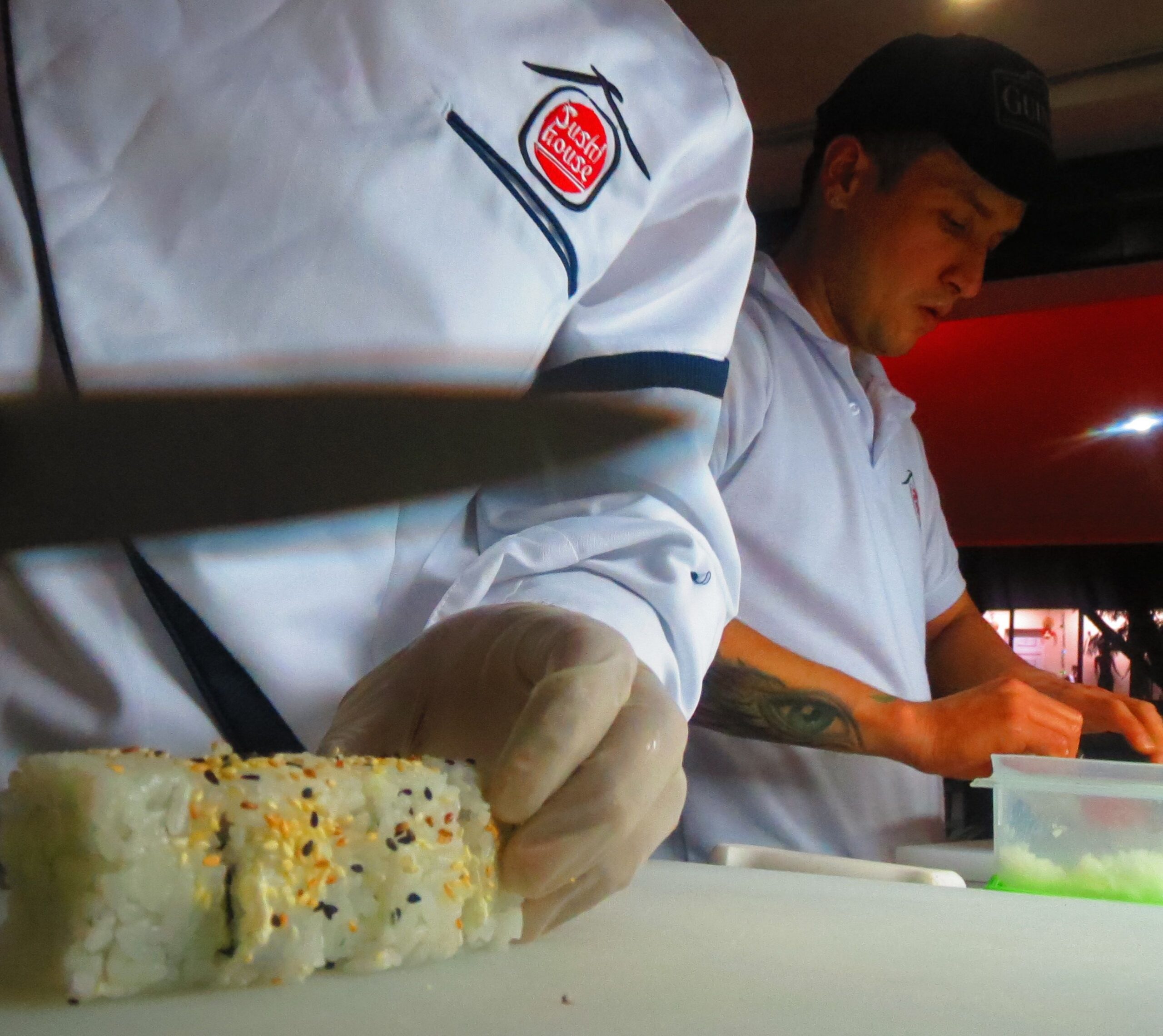 Sushi-making class Luis cuts the first roll of sushi as his top chef, Hugo, prepares several rolls for a couple dining at the restaurant.