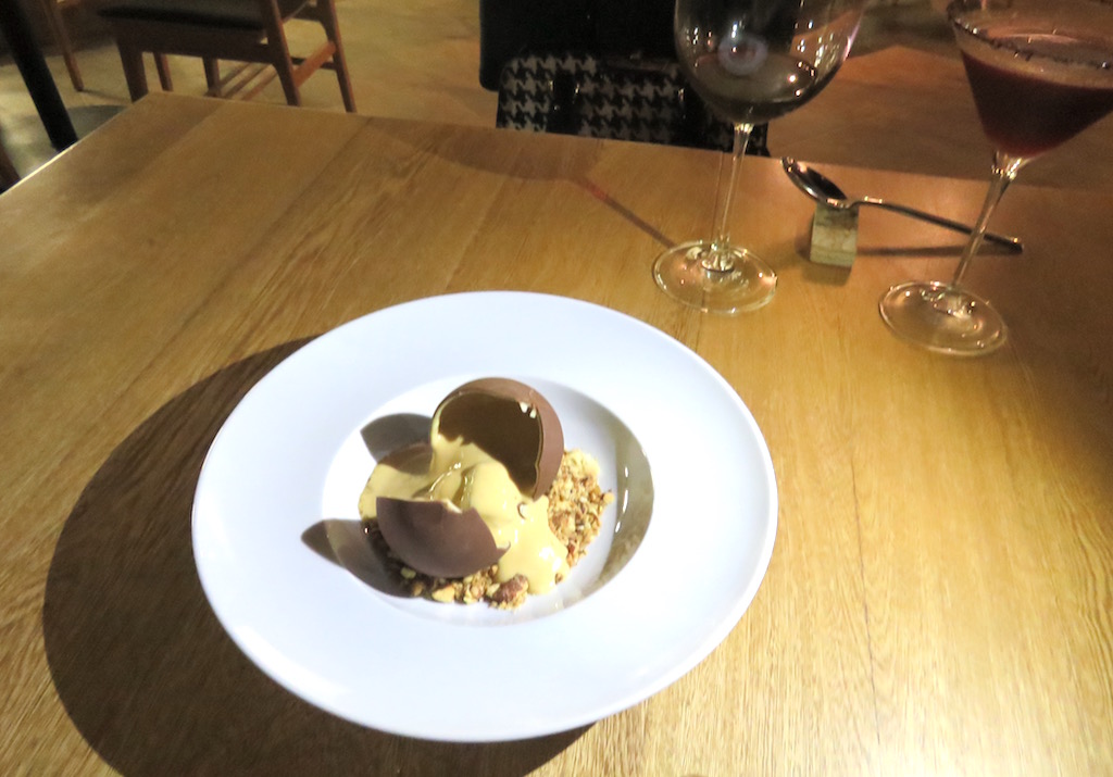 The chocolate and caramel sphere with candied almonds and chocolate sponge