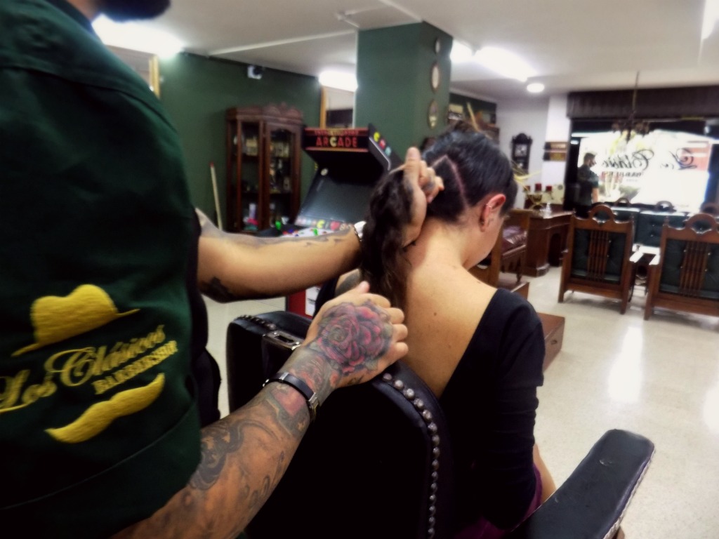 Damian, my barber, takes scissors to my mane.