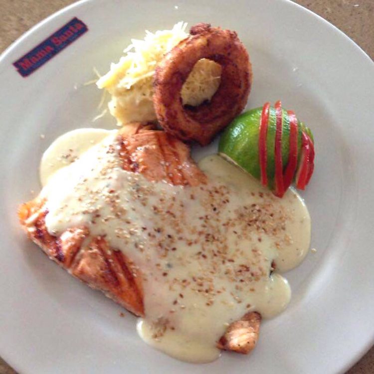 Grilled salmon with Béchamel Sauce, parmesan cheese and egg with mashed potatoes and onion rings, photo courtesy of Mama Santa