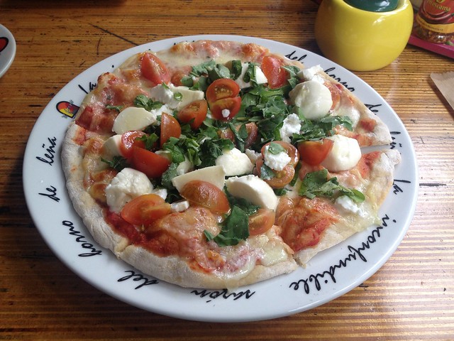 Pizza Marcopolo with mozzarella, goat cheese, tomatoes and arugula
