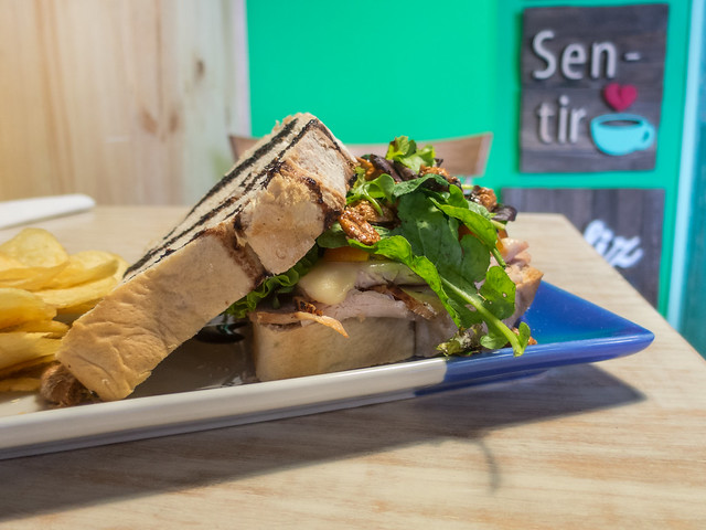 Turkey sandwich with cherry tomatoes, emmental cheese, lettuce, candied peanuts and balsamic vinegar on artisanal bread