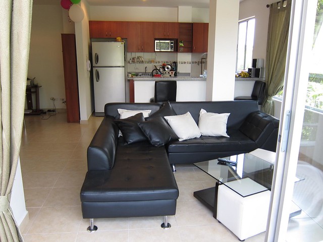 A view of the living room and kitchen from the balcony. A view of the living room and kitchen from the balcony.