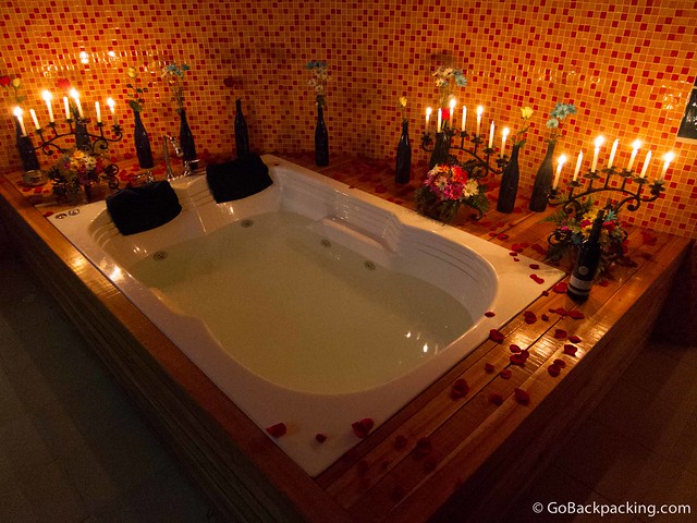 Candlelit jacuzzi with flowers and a bottle of wine