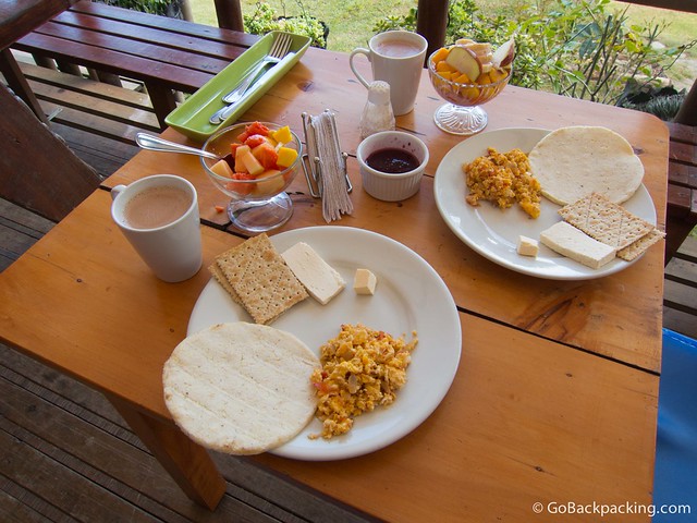Typical Colombian breakfast: arepas, eggs with onion and tomato, cheese, fruit salad, and coffee or hot chocolate