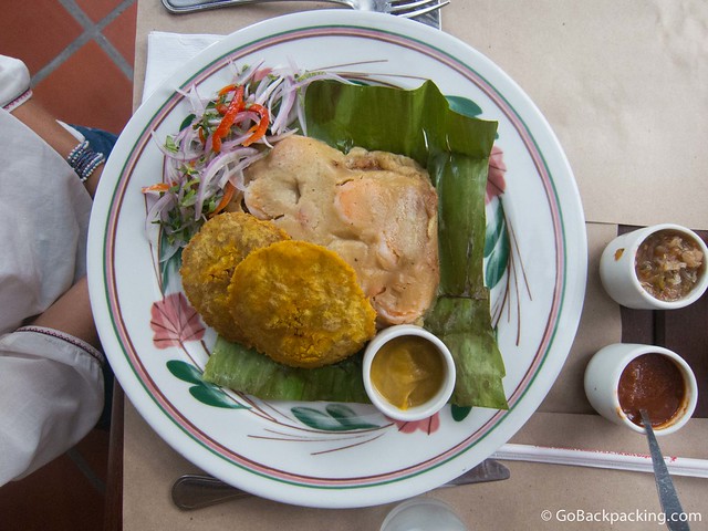 Tamale filled with fish, shrimp, coconut and spices, with a side of salsa de lulo